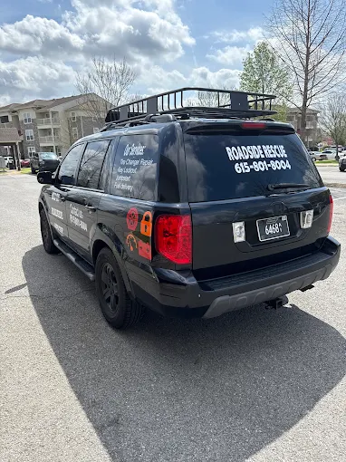 MID TN ROADSIDE RESCUE service SUV with company decals and phone number on the rear windows
